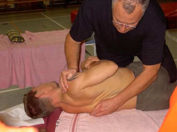 Man ligger på massagebänk medan annan man manipulerar hans bröstrygg